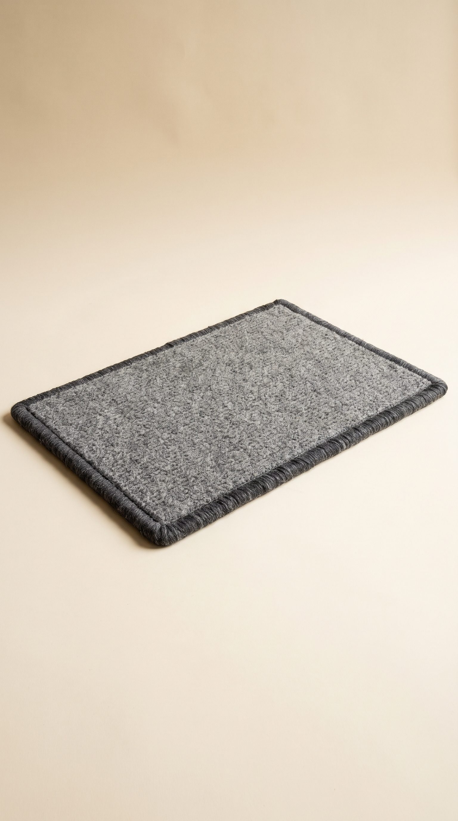 Grey wool doormat with whipped edges