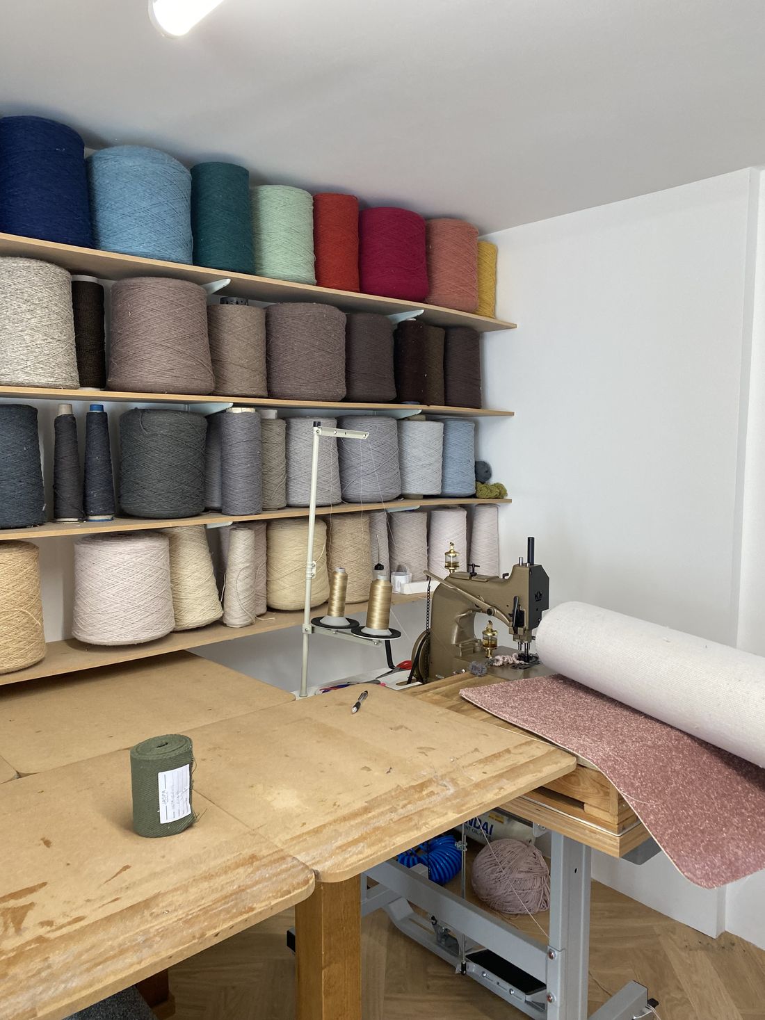 The Wiltshire Rugs studio in Melksham, with shelves of yarn above the workbench