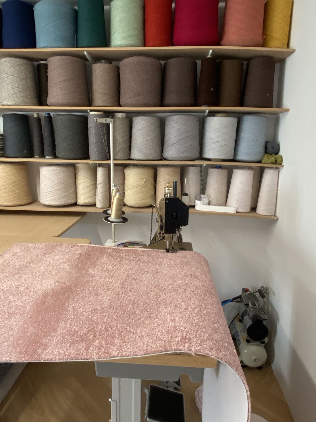 Shelves of coloured whipping yarn above the machine in the studio